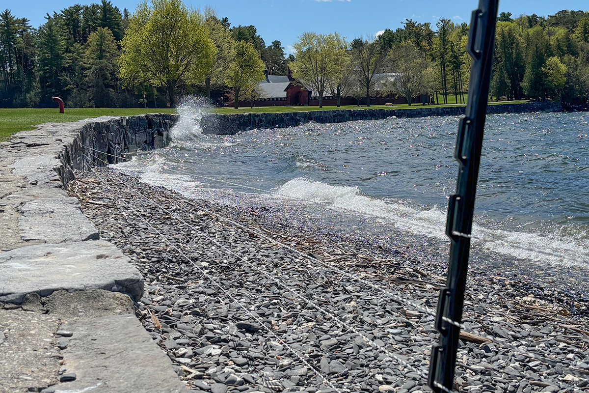 lake shore and seawall with a low string fence stretching along it.