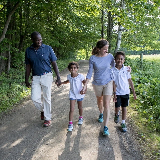 A family walking on trail in the woods
