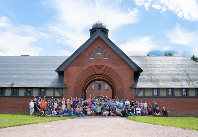 A large group of people gathered in front of the Shelburne Farms Coach Barn