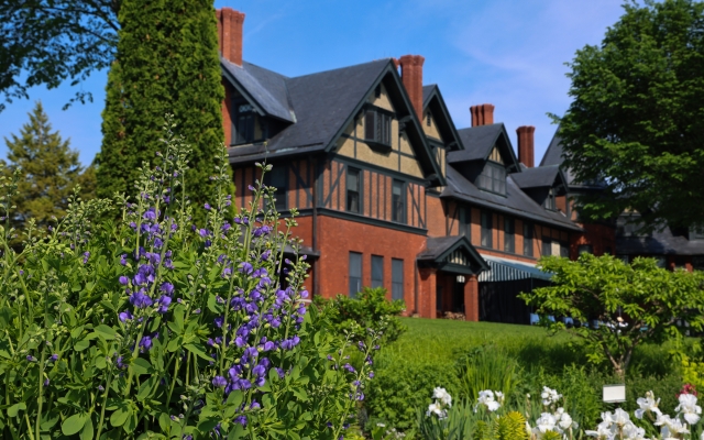 A few of flowers in the Shelburne Farms Inn Formal Flower Gardens, with the structure of the Inn visible in the background.